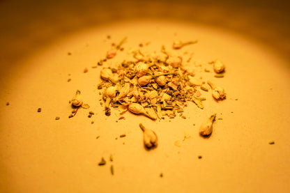 Tru Essence's Saffron Serenity herbal blend laid out on a surface. On display are saffron, cinnamon, cardamon, clove, black pepper, ginger, fennel, and jasmine buds.